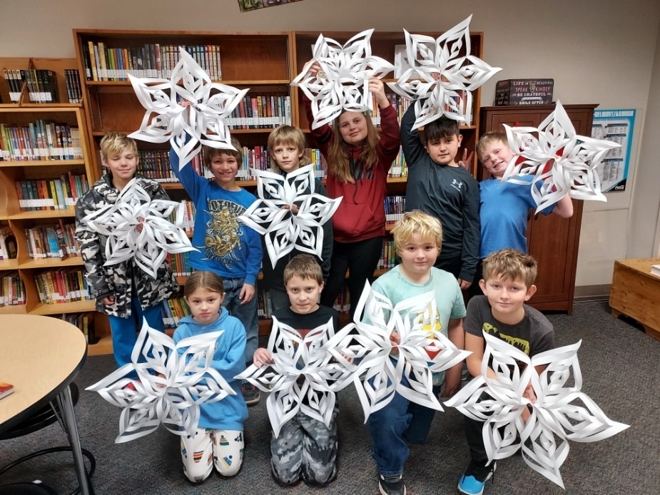 Kids holding snowflakes.